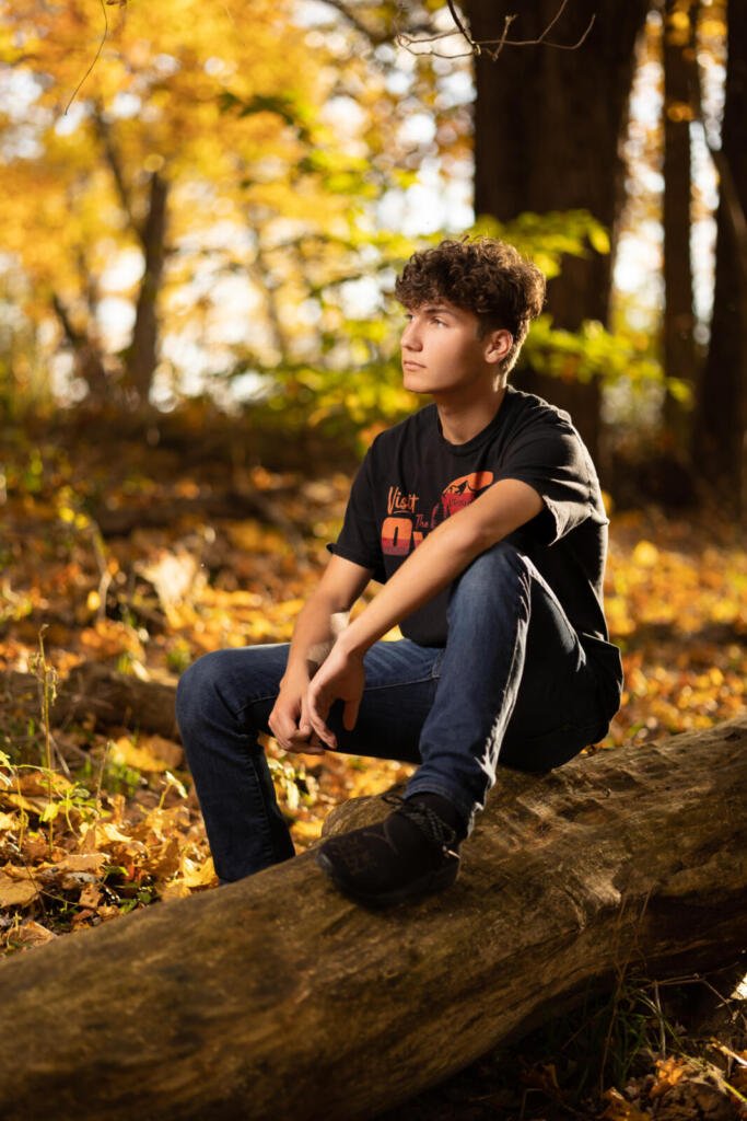 Senior photo of boy in woods