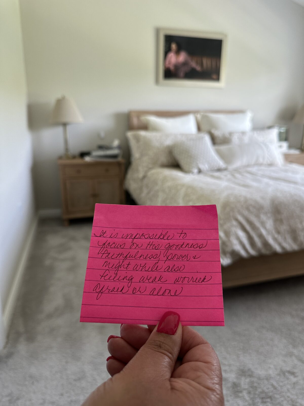 note in front of bed with picture of Regina on the wall. The pink note says, "It is impossible to focus on the goodness, faithfulness, power and might while also feeling weak, worried, afraid or alone.
